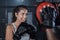 A great way to enhance your endurance. a young woman practicing with her coach at a boxing gym.