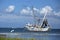 Great white heron flies by a shrimping boat as it heads out