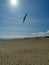 Great Yarmouth Beach in the sun looking toward wind turbine parts on the shore.