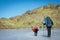 Gredos, Spain. 12-January-2019. Trekker and his dog walking above frozen lake during a sunny winter day