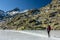 Gredos, Spain. 12-January-2019. Woman trekker walking above beautiful frozen lake during a sunny winter day