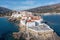 Greece. Andros island Cyclades. Buildings build on cape at Chora town. Sea sun blue sky, above view