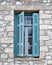 Greece, blue shutters window on traditional island house stone wall