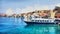 Greece, Halki island in the Dodecanese archipelago, Aegean Sea. View of the village. Boats on clear water. Painting landscape