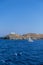 Greece, Kea Tzia island. Seascape with lighthouse and a sailboat, clear blue sky