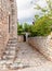 Greece. Mani Laconia, Peloponnese. Narrow path, stonewall building, rocky door with arch, nature