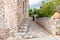 Greece. Mani Laconia, Peloponnese. Narrow path, stonewall building, rocky door with arch, nature