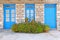 Greece, marigold flowers in front of blue doors and window, house facade