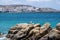 Greece, Mikonos island, Cyclades. Mykonos building, seagull on rock, sea, blue sky background