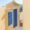 Greece, Santorini. Old blue door and window in the narrow street