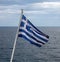 Greece sign symbol of leading shipping power in the world. Greek waving flag on flagpole over sea