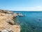 Greece Tinos island, Cyclades. Moored yachts at seaside rocky land in vast Aegean ripple sea