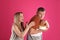 Greedy man hiding tasty cake from woman on pink background