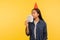 Greedy for money. Portrait of successful rich girl with party cone hat smelling earned dollar banknotes, enjoying success