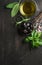 Greek black olives, fresh herbs and oil on dark rustic wooden background.
