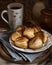 Greek cheese puffs on the old board, near vintage spoons, cup of tea, napkins. Puff pastry dumplings with feta cheese. Rustic