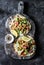 Greek chicken gyros flatbread on a rustic cutting board on a dark background, top view