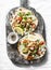 Greek chicken gyros flatbread on a rustic cutting board on a light background, top view