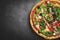 Greek chicken pizza on black stone background with copy space