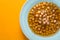 Greek chickpea soup in the white plate on the yellow background