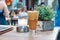 A greek cold coffee, freddo cappuccino placed on a wooden table outdoors.