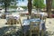 Greek empty taverna chairs and tables by a marina in Greece.