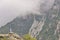 Greek flag in distance amongst misty mountains