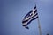 The Greek flag flying atop the Acropolis in Athens, Greece