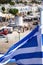 Greek flag over Paros harbor with wind mill, Cyclades, Greece. Theme of Cyclades.