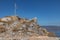 Greek flag and ruins over a mountain in Hydra Island