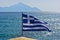 Greek flag on a sailing ship with holy mountain Athos in background