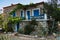 Greek house traditionaly made of stone with blue and white colored windows in Sithonia