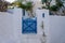 Greek Island, Cyclades. Blue wooden fence entrance gate close,  whitewashed stonewall plant at yard.l