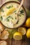 Greek lemon soup Avgolemono served with toasted bread close-up in a bowl. Vertical top view