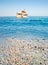 Greek marble beach, blue sea and cruise boat