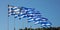 Greek national official flag on flagpole waving in a row, Greece sign symbol, clear blue sky