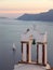 Greek Orthodox Church Bell Tower against Aegean Sea with Sailing Boat at the Sunset, Santorini