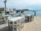 Greek outdoors tavern at port seaside Tinos island, Cyclades Greece. Chora town background