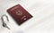 Greek passport on a wooden table next to a house key, real estate investment