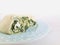 Greek rolls cut half on blue plate white marble background.