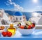 Greek salad against famous church in Oia village, Santorini island in Greece