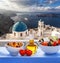 Greek salad against famous church in Thira town on Santorini island in Greece