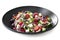 Greek Salad on Black Plate Side View Isolated on white