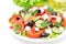 Greek salad with feta cheese, olives and vegetables on white