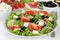 Greek salad on table in bowl with tomatoes, Feta cheese and olives