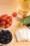 Greek salad with vegetables, feta cheese, black olives in process. Wooden background . Top view