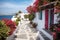 Greek street, whitewashed houses, beautiful red liana flowers, path to the sea