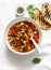 Greek style tomato sauce, spinach, paprika, beans stewed on a light background, top view