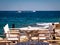 Greek tavern near the sea with wood chairs and table painted in white