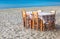 Greek taverna table and chairs on sandy beach